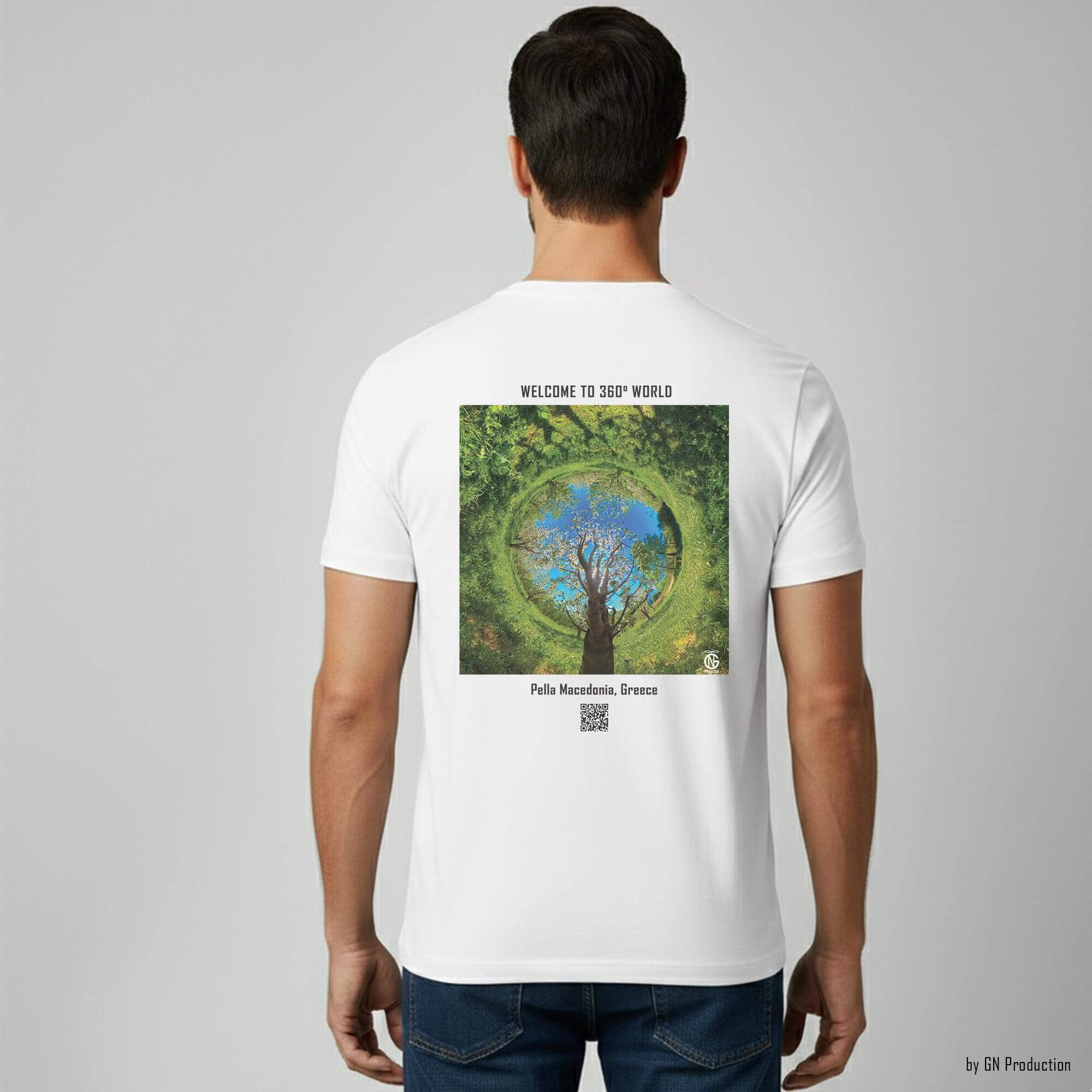Man model wearing white art T-shirt with Pella cherry orchard inverted tiny-planet 360° artwork on the back, spring nature photography transformed into wearable art.