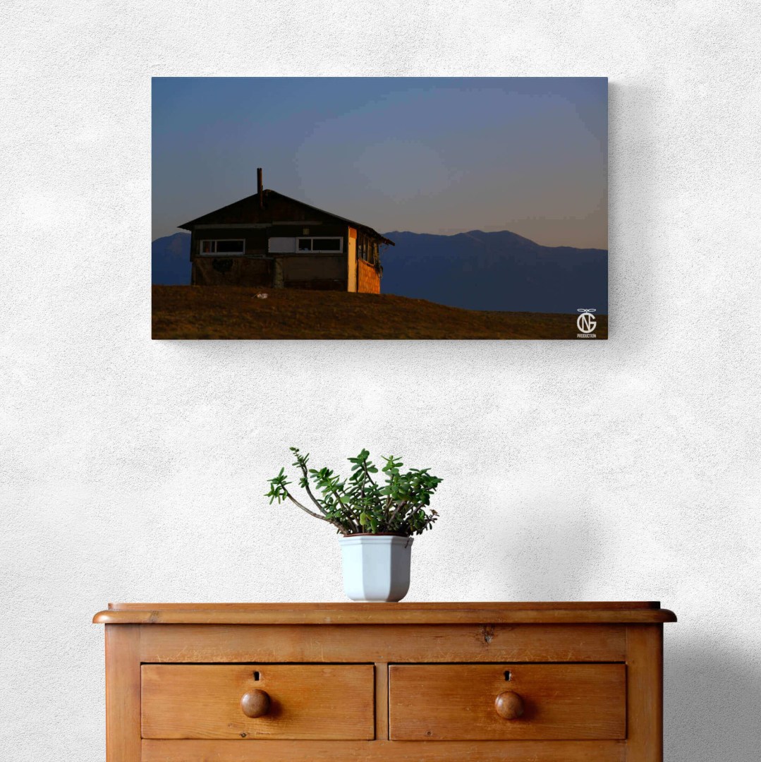 Fisherman’s House art print styled with a plant on wooden drawers for a cozy Greek-inspired interior.