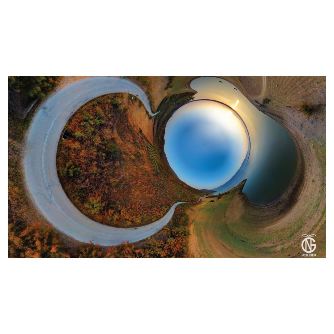 360° tiny-planet view of Lake Kerkini, Greece - featuring a winding road, golden-autumn trees, and a soft sunset reflected on the lake.